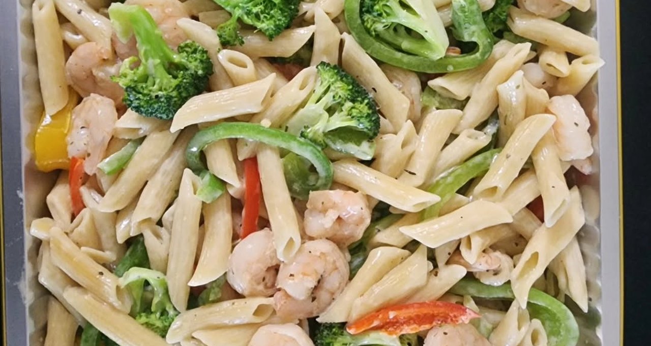 A catering tray of penne pasta with shrimp, broccoli and sliced peppers, cooked by Garcia's Catering